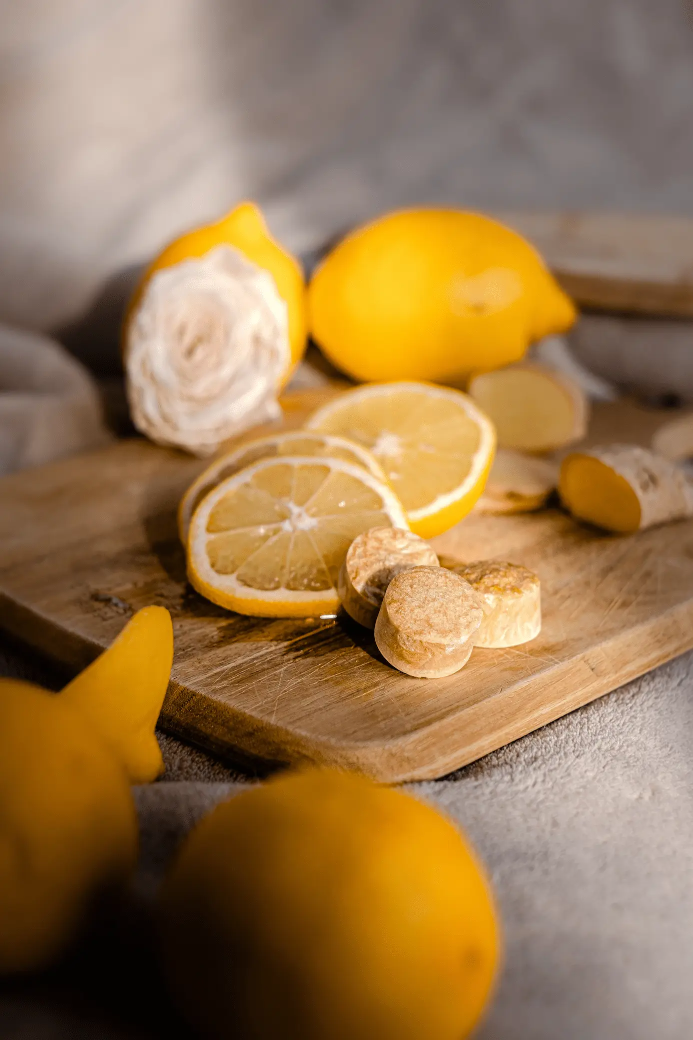 Capsules de thé citron Instan’T mises en scène avec citron tranché et rose.