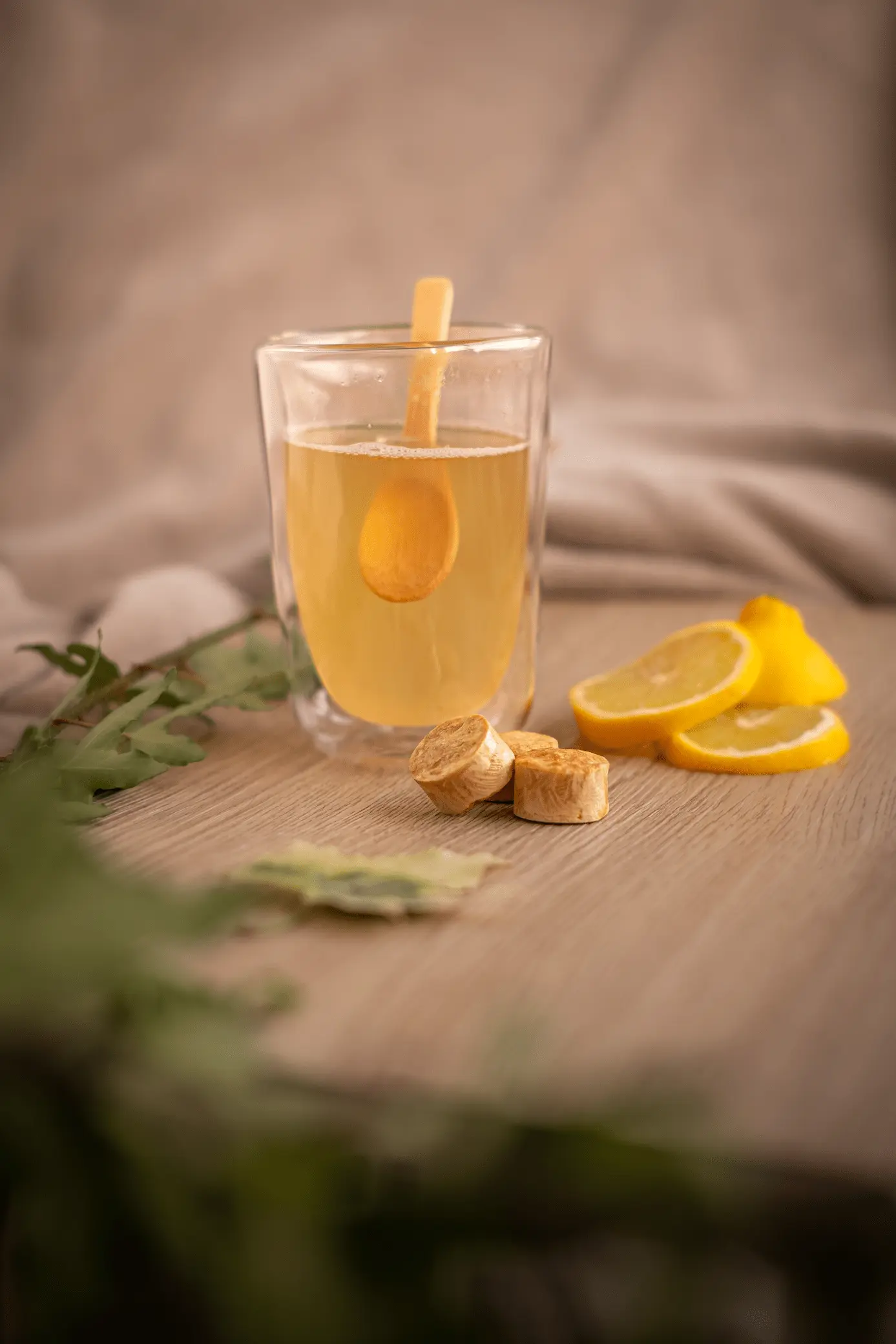 Thé citron Instan’T sur table bois avec feuilles vertes et pastilles.